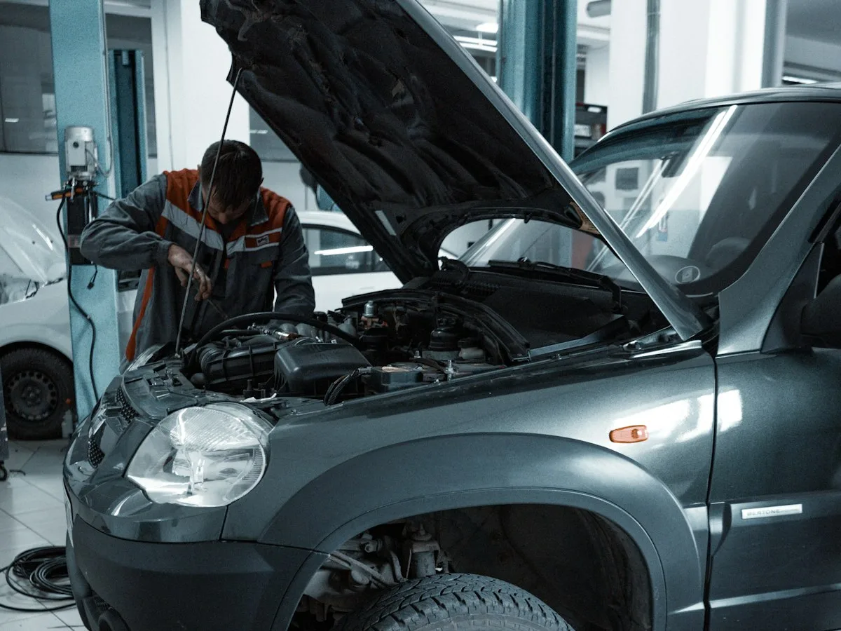 Technician servicing a car engine in a modern automotive workshop